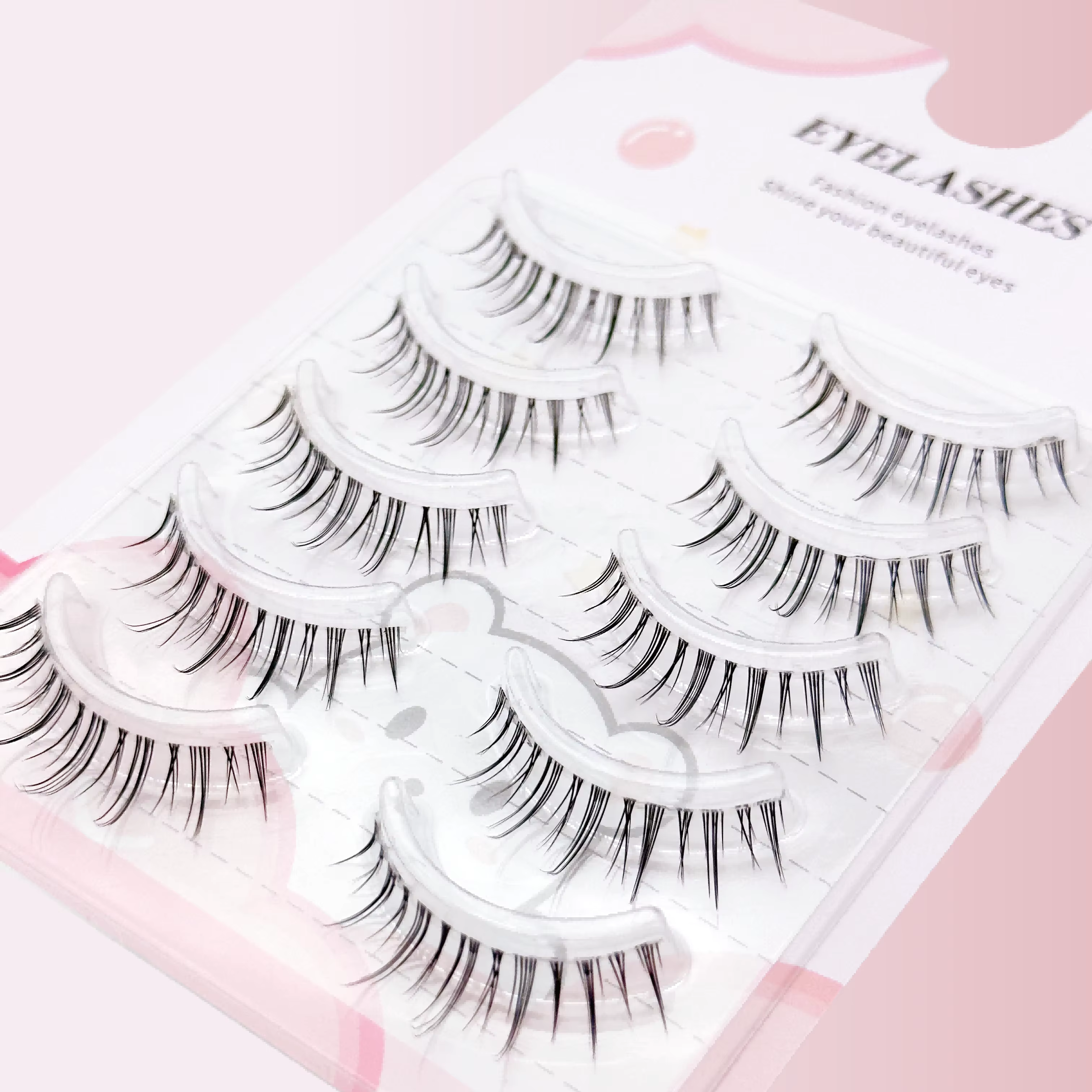 Un coffret de cinq paires de faux cils de style manga avec une base transparente